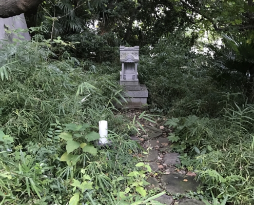 wooded area with footpath to a small stone temple